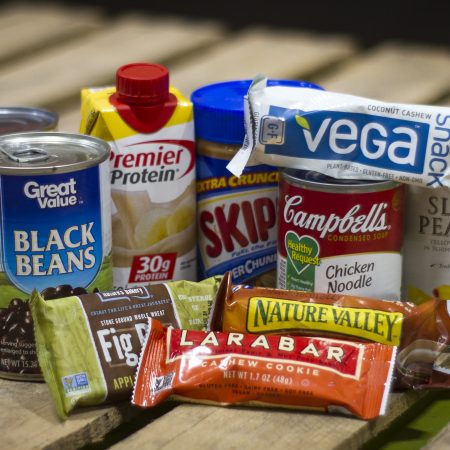 Canned beans, protein shake, peanut butter, granola bars, canned soup, and peaches. Suitable for no-cook meals for homeless.
