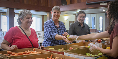 Las personas están recibiendo productos frescos, lo que indica que se está llevando a cabo una distribución de alimentos.