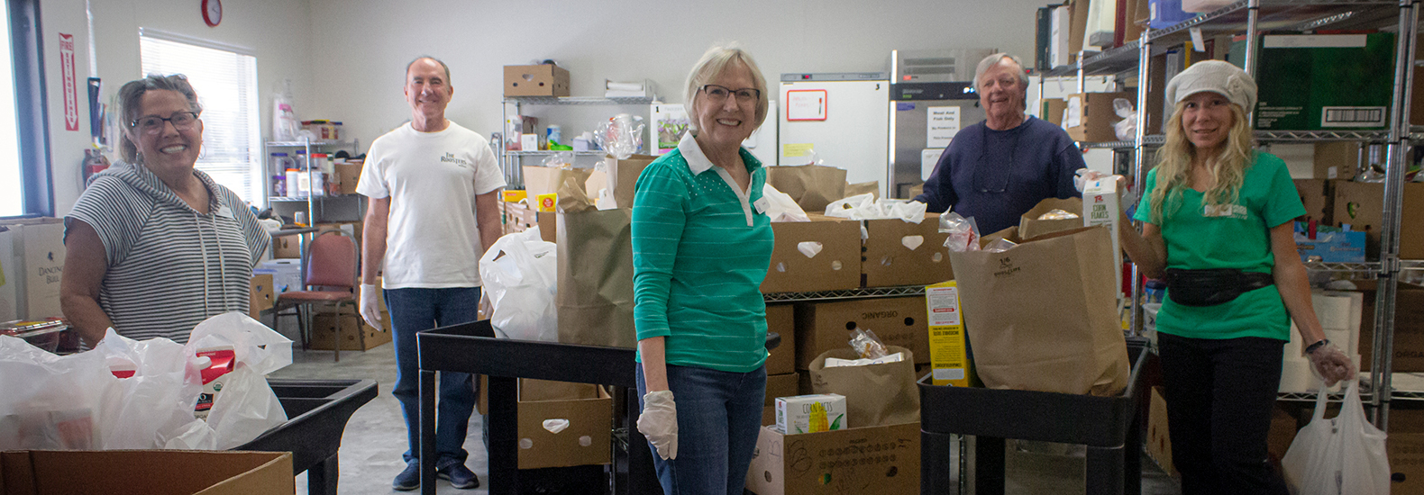 Agency-Partners People are volunteering in a food bank, sorting and packing supplies. Food bank partnerships are relevant here.