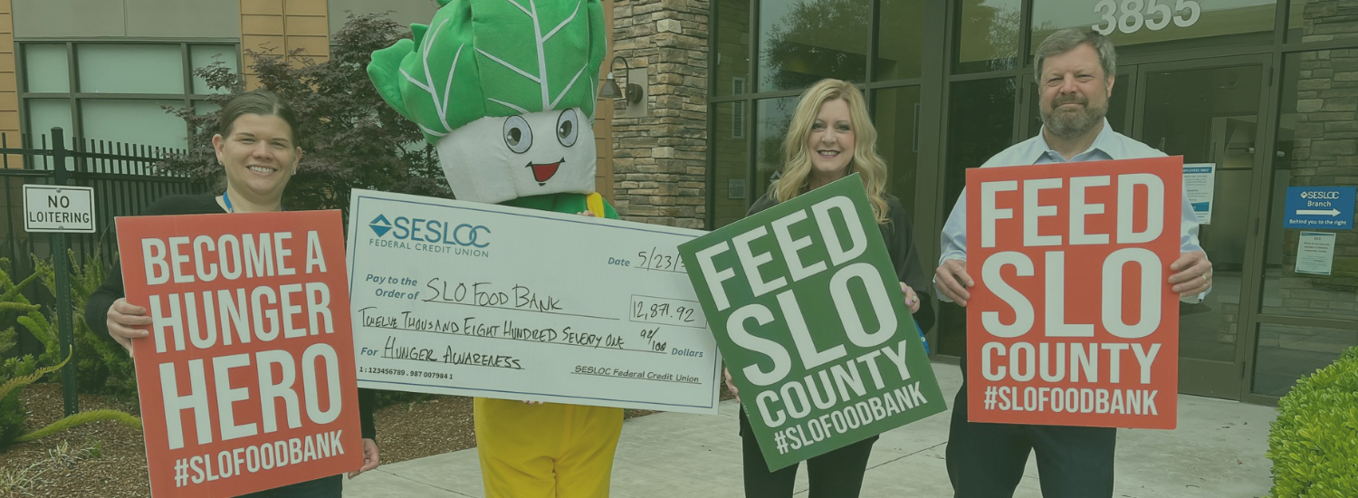 SLO Food Bank Sponsors 2023 People hold signs for a food bank donation event, featuring a mascot and a large check for $12,871.92.